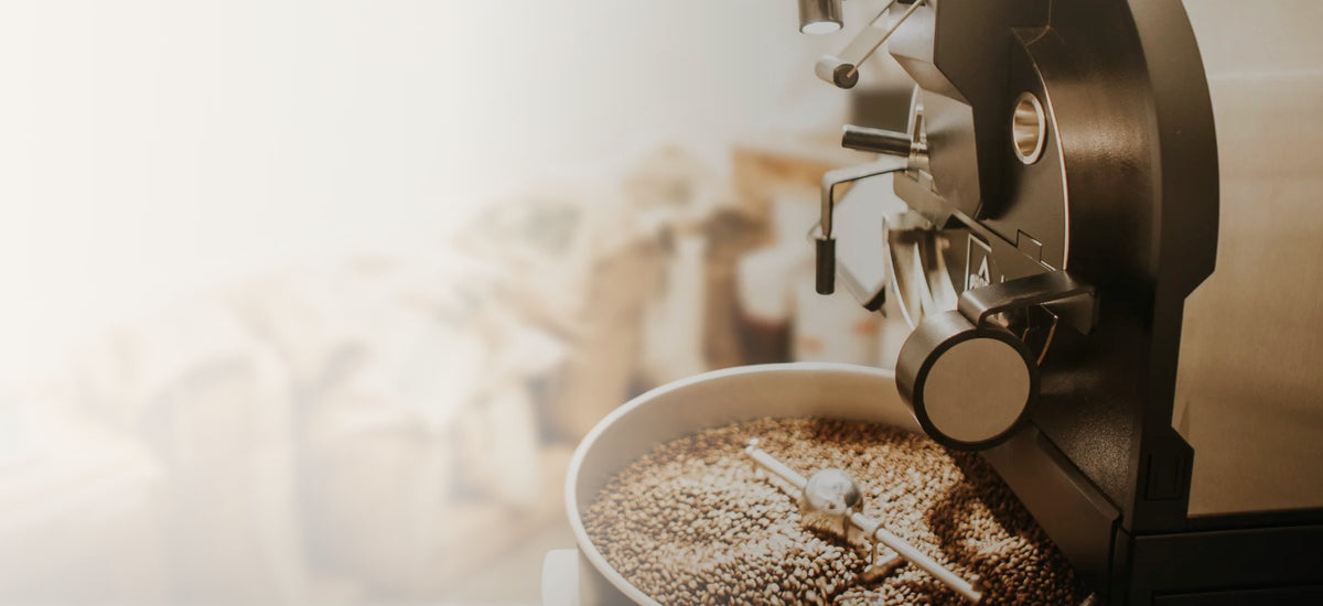 Röstmaschine und Kühlsieb mit frisch gerösteten Bohnen in der Schön-Kaffee-Rösterei
